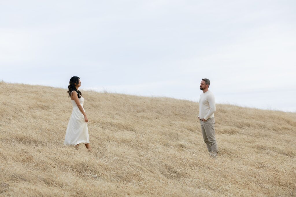 Couple facing each other on golden hillside at Mount Tamalpais engagement session, Bay Area engagement photographer Rose Freedman