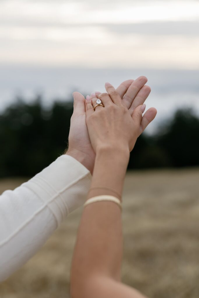 Engagement ring close-up with couple holding hands at Mount Tamalpais, Bay Area engagement photographer Rose Freedman