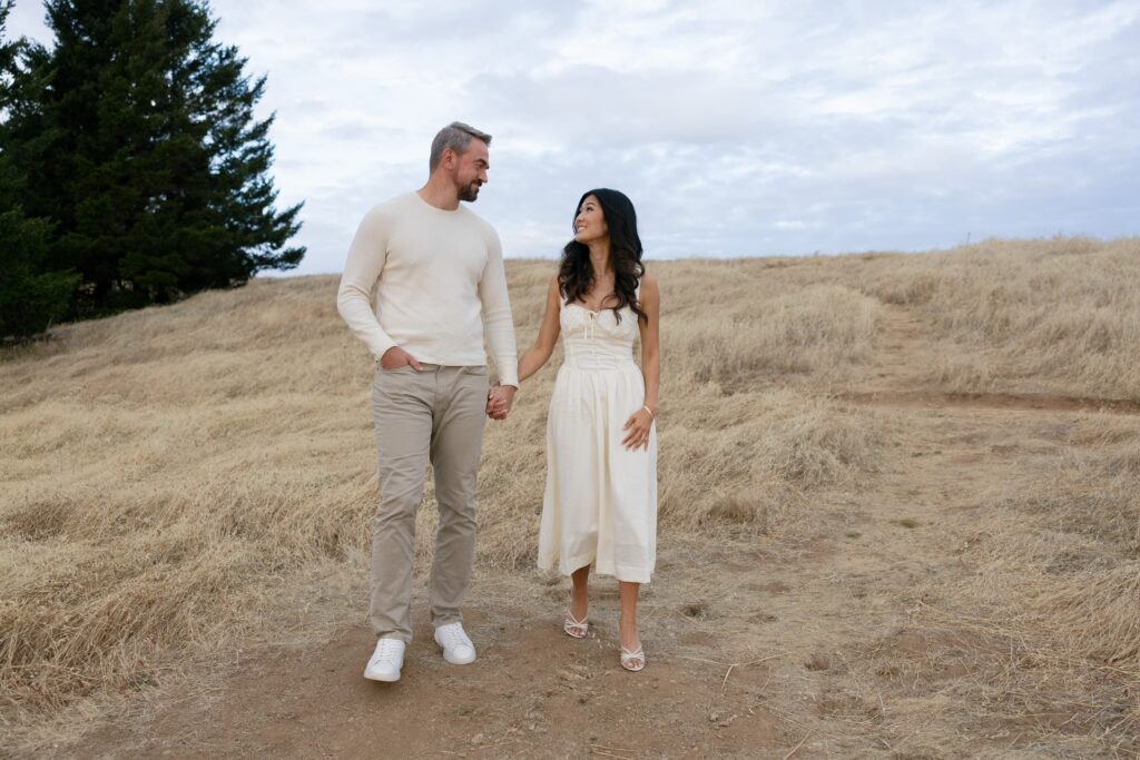 Couple walking hand in hand through golden field at Mount Tamalpais engagement session, Bay Area engagement photographer Rose Freedman