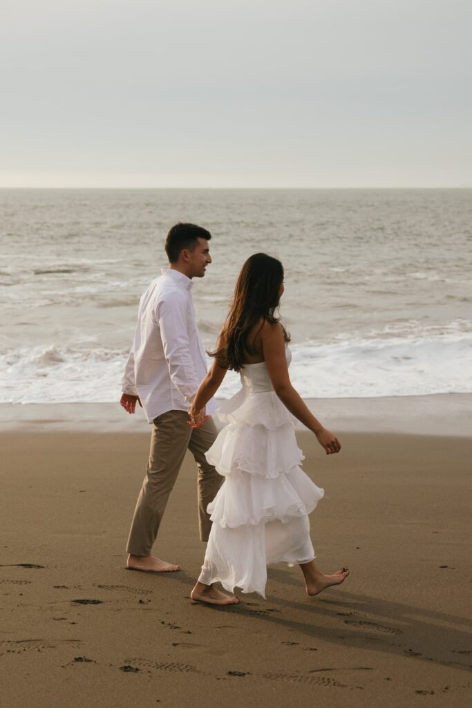 Couple walking on Northern California beach engagement session, white ruffle dress, Rose Freedman Photography