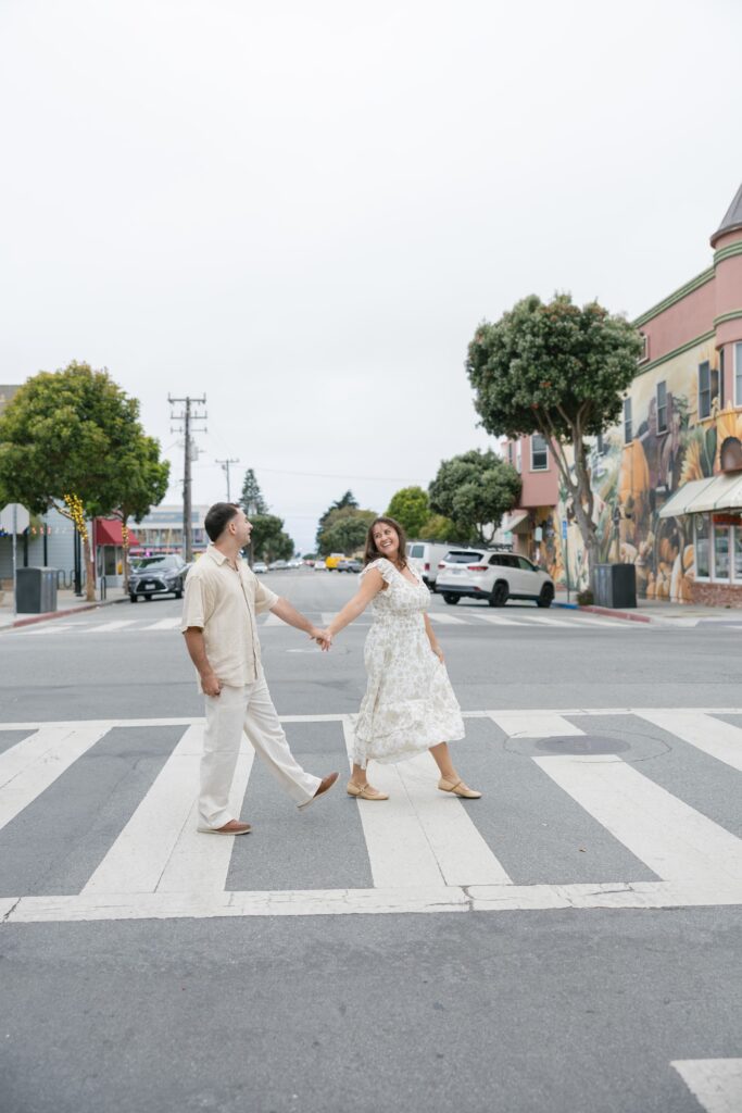 Couple walking through crosswalk downtown Half Moon Bay, Bay Area couples photographer Rose Freedman