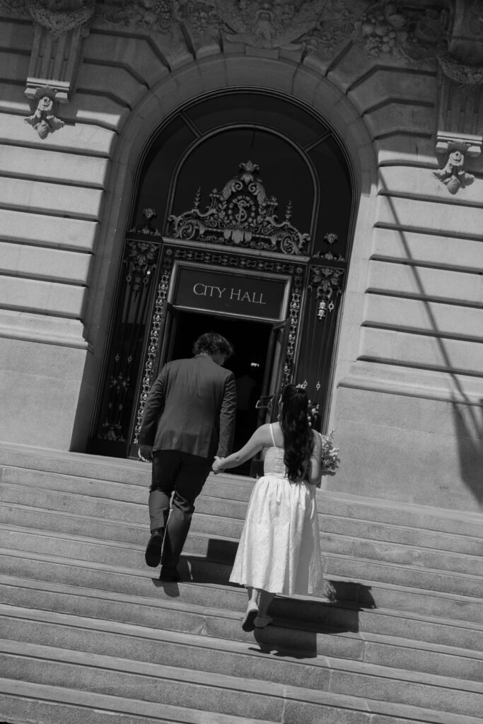 Couple entering San Francisco City Hall for elopement ceremony, SF City Hall elopement photographer Rose Freedman