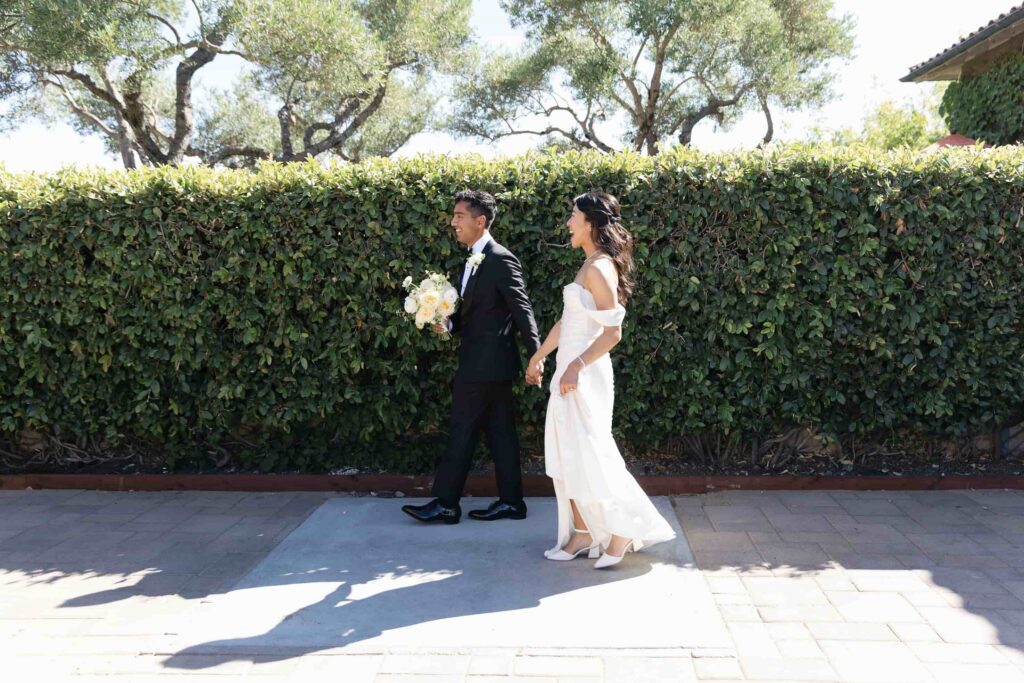Bride and groom walking hand in hand laughing at outdoor wedding, Bay Area wedding photographer Rose Freedman