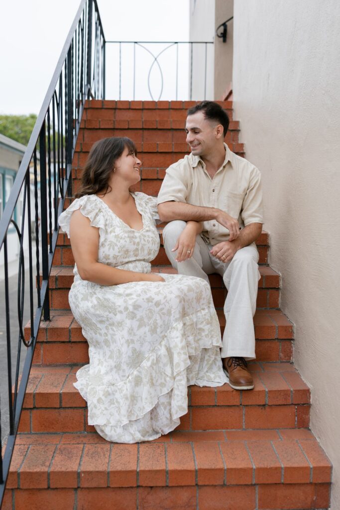 Couple sitting on steps downtown Half Moon Bay anniversary session, Rose Freedman Photography