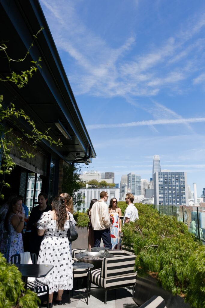 Guests mingling on Charmaine's Rooftop at Adored Creations launch party San Francisco, event photographer Rose Freedman