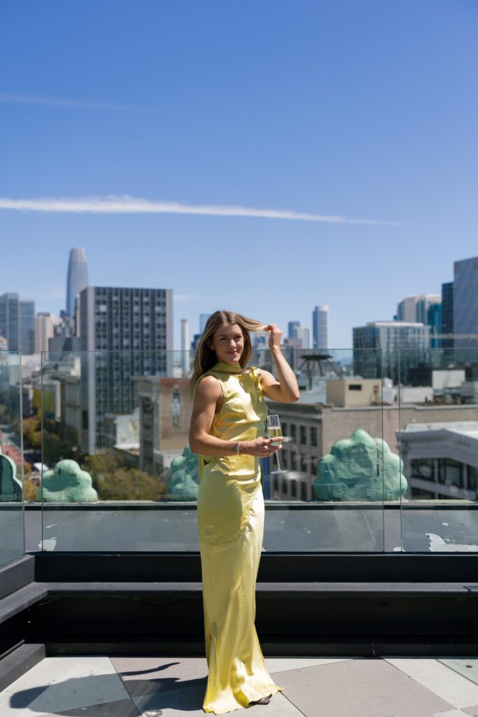 Adored Creations founder Liv in yellow dress with champagne on Charmaine's Rooftop San Francisco, Rose Freedman Photography