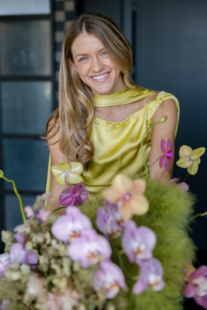 Adored Creations founder Liv Carter smiling with orchid floral arrangement Charmaine's Rooftop San Francisco, Rose Freedman Photography