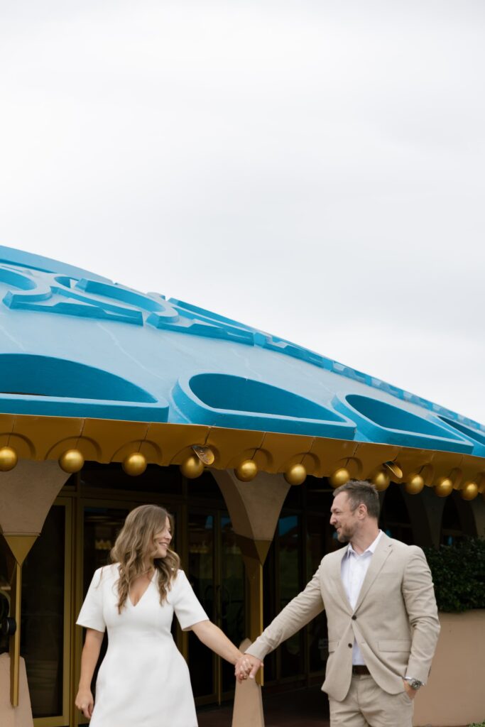 Couple holding hands in front of Marin Civic Center Frank Lloyd Wright building, Rose Freedman Photography