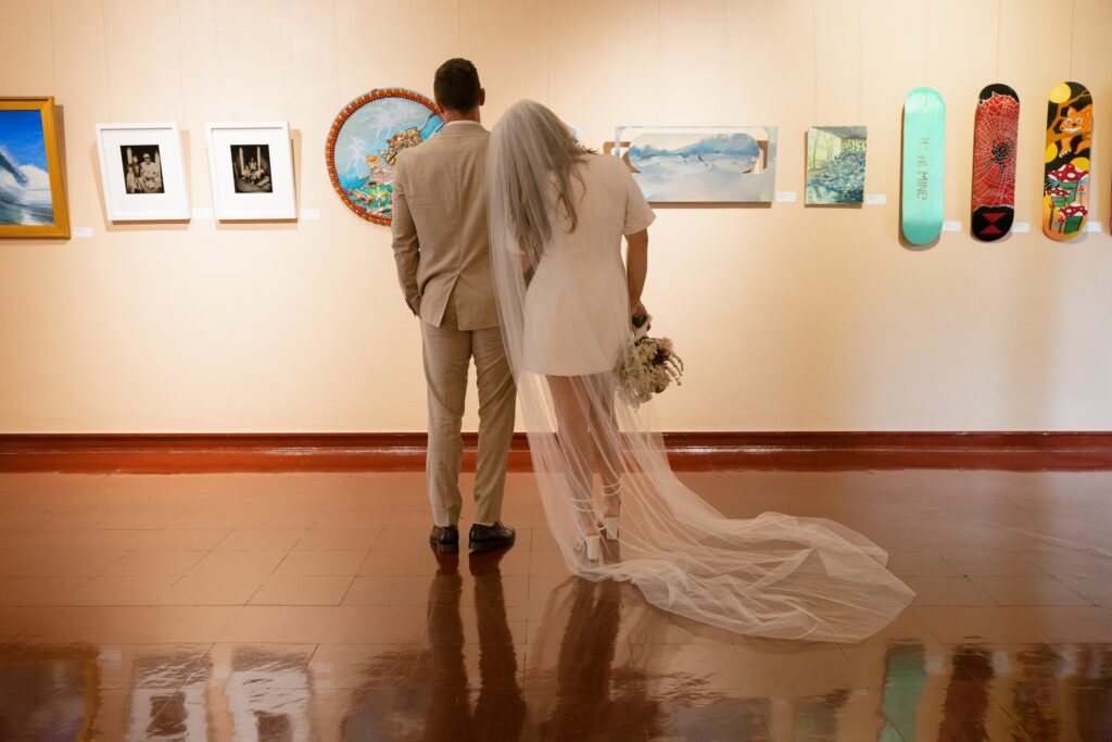 Newlyweds from behind in Marin Civic Center interior gallery, bride in veil, Rose Freedman Photography