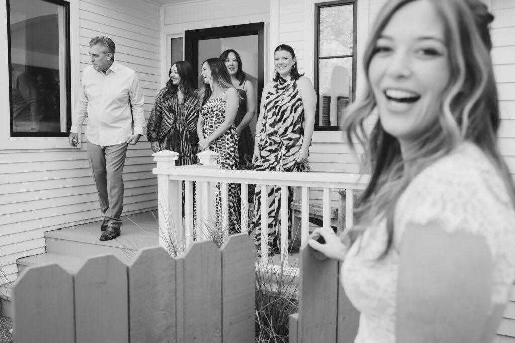 Wedding guests laughing on porch dressed fun cocktail attire Marin, Rose Freedman Photography