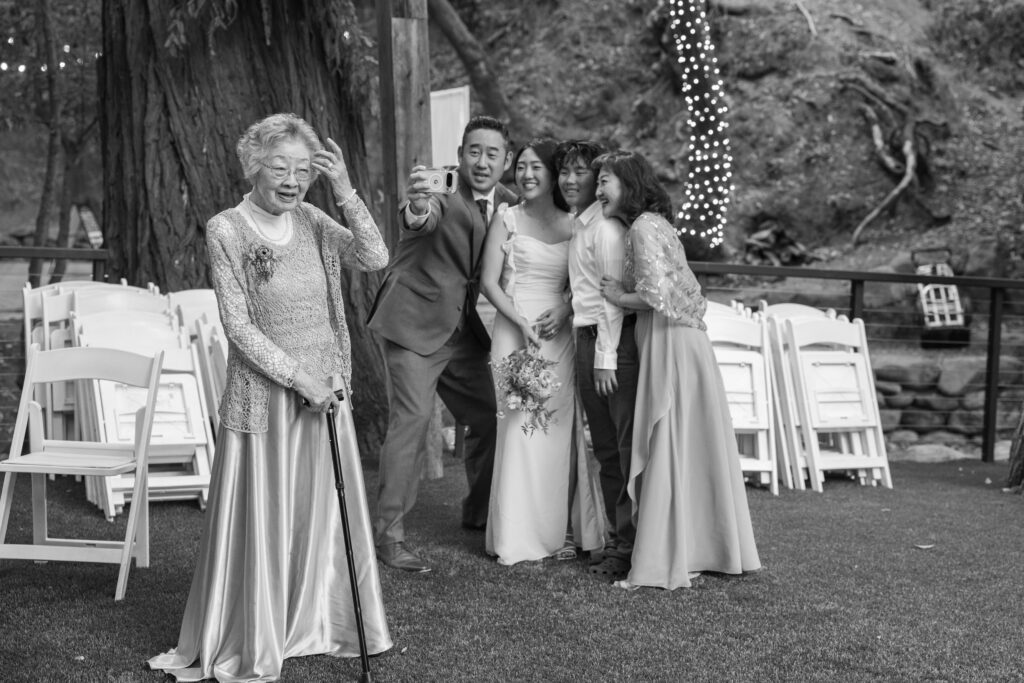 Candid black and white photo of grandmother at outdoor redwood wedding at Saratoga Springs