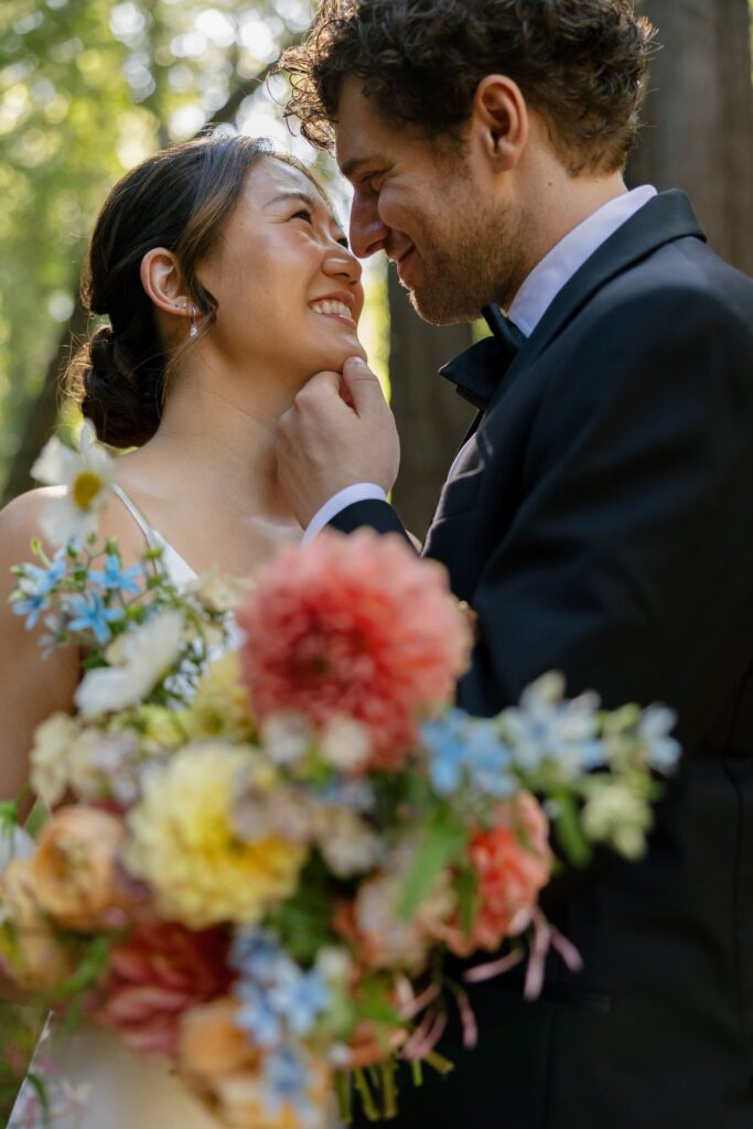 Bride and groom laughing together in California redwood forest at Saratoga Springs outdoor wedding